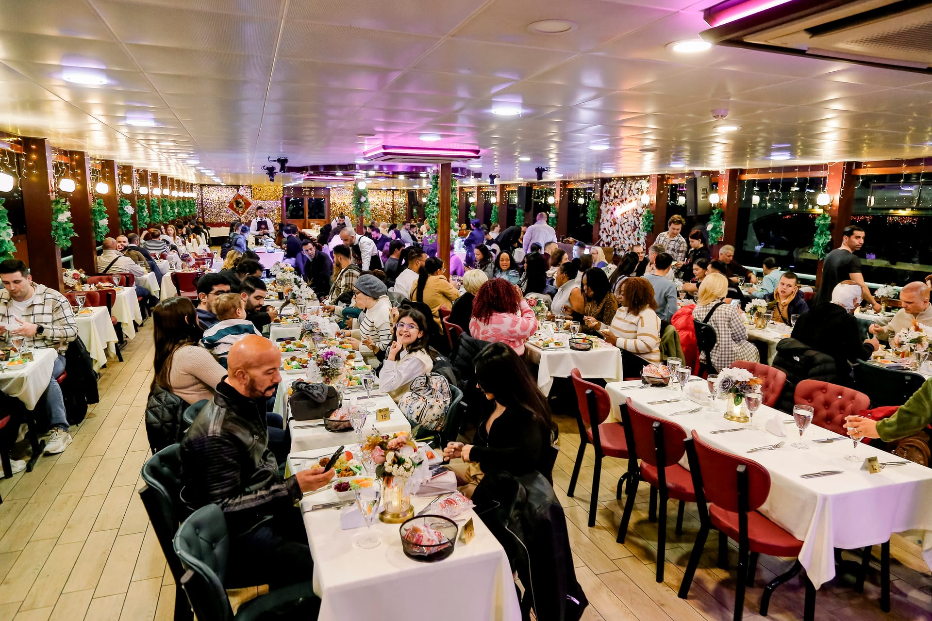 Guests enjoying dinner in the full dining hall of the Bosphorus cruise boat