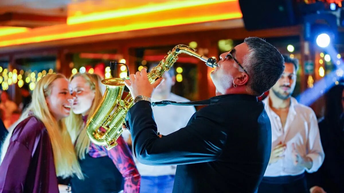 Live saxophonist playing among guests during the Bosphorus dinner cruise show